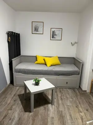 a bed with yellow pillows and a table in a room at Verseau Flaine Forêt in Arâches-la-Frasse