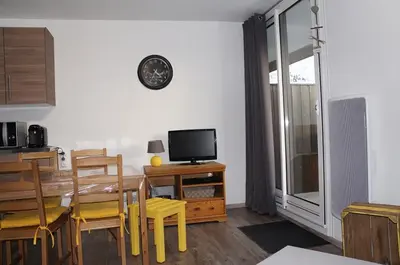 a living room with a dining table and a television at Verseau Flaine Forêt in Arâches-la-Frasse