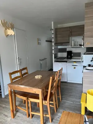 a kitchen with a wooden dining table and chairs at Verseau Flaine Forêt in Arâches-la-Frasse