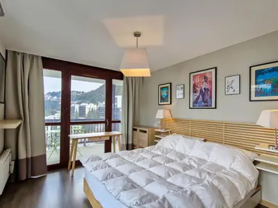 a bedroom with a large white bed and a balcony at Spacieux appartement avec parking et accès piscine à Flaine - FR-1-425-231 in Arâches-la-Frasse