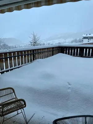 a bench sitting on a porch covered in snow at Cocon alpin in Cordon