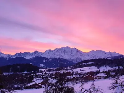 a view of a snowy mountain range at sunset at Cocon alpin in Cordon