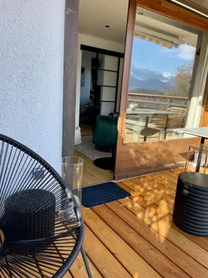 a wooden deck with a couch and a table at Cocon alpin in Cordon