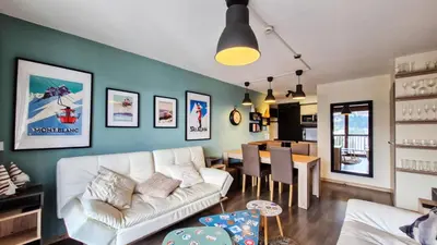 a living room with a white couch and a dining room at Résidence Le Panoramic - Appartement spacieux · Départ et retour skis aux pieds · Piscine · Parking inclus · Spa MAE-6931 in Magland