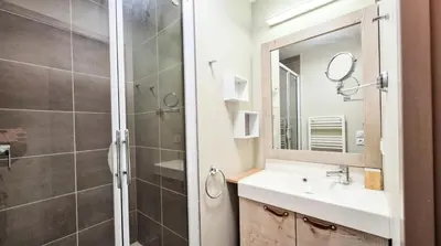 a bathroom with a shower and a sink and a mirror at Résidence Le Panoramic - Appartement spacieux · Départ et retour skis aux pieds · Piscine · Parking inclus · Spa MAE-6931 in Magland