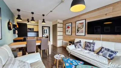 a living room with a white couch and a table at Résidence Le Panoramic - Appartement spacieux · Départ et retour skis aux pieds · Piscine · Parking inclus · Spa MAE-6931 in Magland