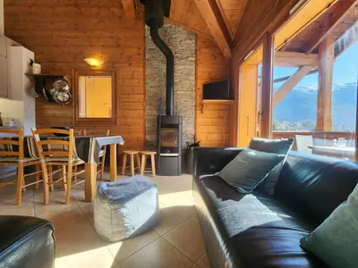 a living room with a black leather couch and a table at Appartement 4 pièces avec Wifi et parking à Samoëns - FR-1-629-146 in Samoëns