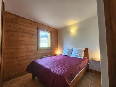 a bedroom with a bed with a wooden wall at Appartement 4 pièces avec Wifi et parking à Samoëns - FR-1-629-146 in Samoëns