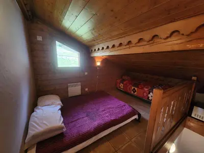 a small room with a bed in a wooden cabin at Appartement 4 pièces avec Wifi et parking à Samoëns - FR-1-629-146 in Samoëns