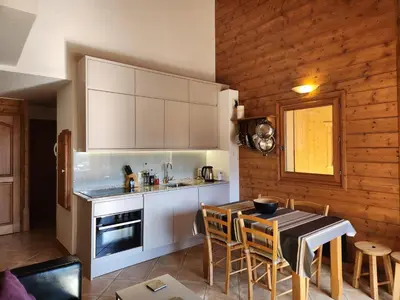 a kitchen and dining room with a table and chairs at Appartement 4 pièces avec Wifi et parking à Samoëns - FR-1-629-146 in Samoëns