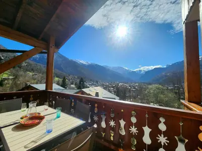a balcony with a table and a view of the mountains at Appartement 4 pièces avec Wifi et parking à Samoëns - FR-1-629-146 in Samoëns