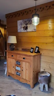 a room with a wooden wall with a table and a lamp at Alpen Marvel in Morillon