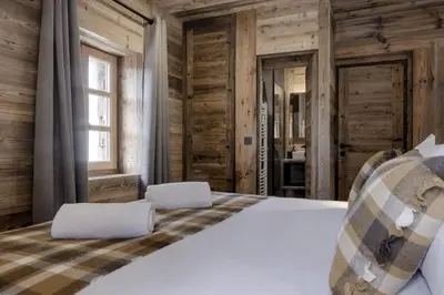 a bedroom with a bed and wooden walls at Ferme des Tétras - Chalet de prestige en montagne in Saint-Gervais-les-Bains