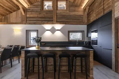 a kitchen with a large island with bar stools at Ferme des Tétras - Chalet de prestige en montagne in Saint-Gervais-les-Bains