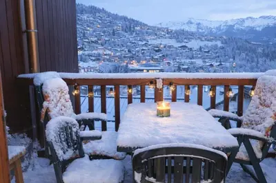 a table and chairs on a balcony covered in snow at Apartment near city center in Saint-Gervais-les-Bains