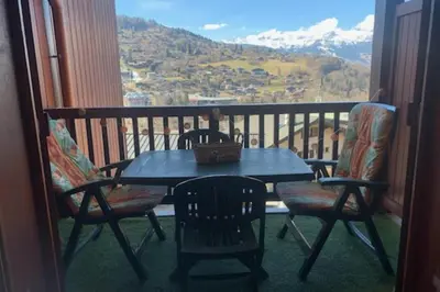 a table and chairs on a balcony with a view at Apartment near city center in Saint-Gervais-les-Bains