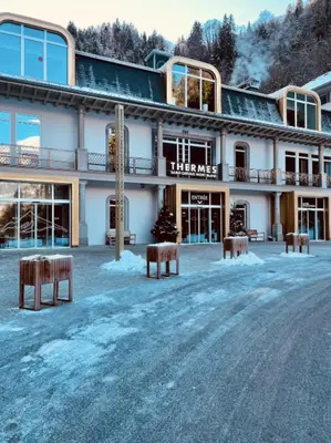 a building with benches in front of it in the snow at Apartment near city center in Saint-Gervais-les-Bains