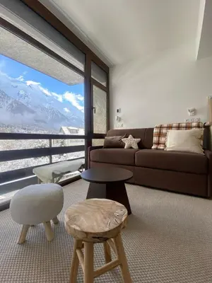 a living room with a couch and chairs and a large window at Appartement Chamonix in Chamonix-Mont-Blanc