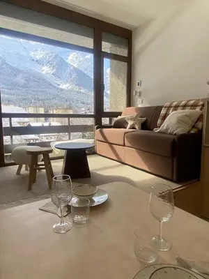 a living room with a couch and a table with wine glasses at Appartement Chamonix in Chamonix-Mont-Blanc