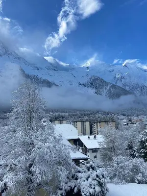 a snow covered city with mountains in the background at Appartement Chamonix in Chamonix-Mont-Blanc