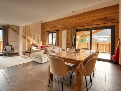 a living room with a wooden table and chairs at Bel appartement neuf 8 pers, Samoëns, près village, WIFI inclus - FR-1-642-100 in Samoëns