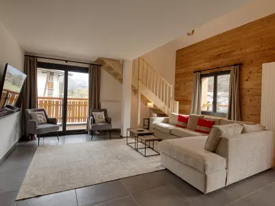 a living room with a couch and a table and chairs at Bel appartement neuf 8 pers, Samoëns, près village, WIFI inclus - FR-1-642-100 in Samoëns