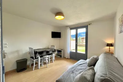 a living room with a couch and a table at Au Pied des Neiges in Demi-Quartier