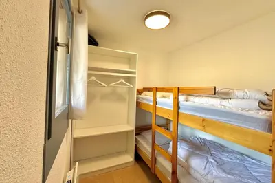 two bunk beds in a room with a closet at Au Pied des Neiges in Demi-Quartier