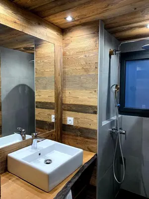 a bathroom with a sink and a tv on the wall at Le Samoëns cosy 3 etoiles en centre ville in Samoëns