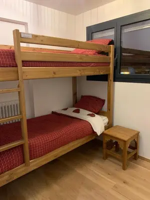 a bedroom with two bunk beds and a table at Le Samoëns cosy 3 etoiles en centre ville in Samoëns