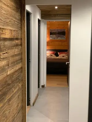 a hallway leading to a bedroom with a bed at Le Samoëns cosy 3 etoiles en centre ville in Samoëns