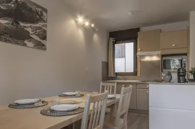 a kitchen and dining room with a table and chairs at Le Castel des Roches - Sejour ski & spa in Saint-Gervais-les-Bains