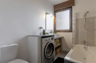 a bathroom with a washing machine and a sink at Le Castel des Roches - Sejour ski & spa in Saint-Gervais-les-Bains
