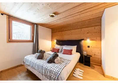 a bedroom with a bed with a wooden wall at Chalet Croc Blanc, Chamonix - vu massif exceptionnel in Les Houches
