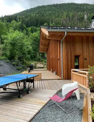 a ping pong table and chairs on a deck at Chalet Croc Blanc, Chamonix - vu massif exceptionnel in Les Houches