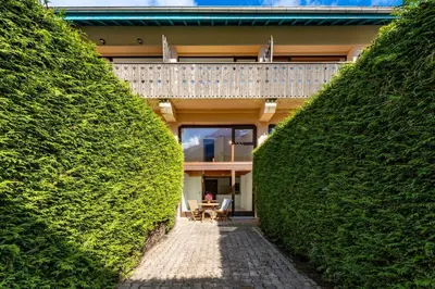 a walkway between two large hedges with a house at Chamonix Centre - Sophisticated 2-Bedroom Duplex in Chamonix-Mont-Blanc