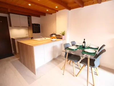 a kitchen with a table and chairs in a kitchen at Chamonix Centre - Sophisticated 2-Bedroom Duplex in Chamonix-Mont-Blanc