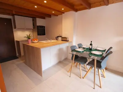 a kitchen with a table and chairs in a room at Chamonix Centre - Sophisticated 2-Bedroom Duplex in Chamonix-Mont-Blanc