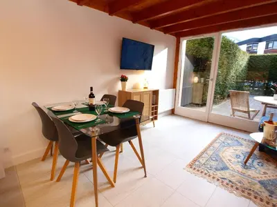 a dining room with a table and chairs and a television at Chamonix Centre - Sophisticated 2-Bedroom Duplex in Chamonix-Mont-Blanc