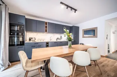 a dining room and living room with a wooden table at Apartment Aubretia, Les Houches - by EMERALD STAY in Les Houches