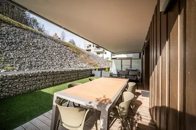 a room with a table and chairs on a patio at Apartment Aubretia, Les Houches - by EMERALD STAY in Les Houches