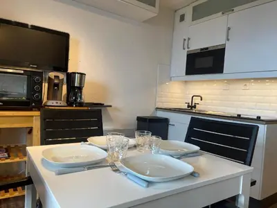 a kitchen with a table with plates and glasses on it at Appartement 4 personnes Samoëns 1600 in Samoëns