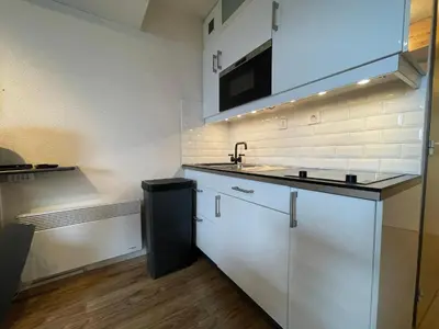 a kitchen with white cabinets and a sink and a microwave at Appartement 4 personnes Samoëns 1600 in Samoëns