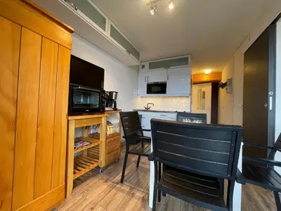 a kitchen with a table and chairs and a microwave at Appartement 4 personnes Samoëns 1600 in Samoëns