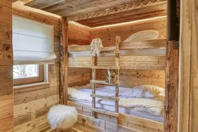 a room with a bunk bed in a log cabin at Chalet Boucle in Megève