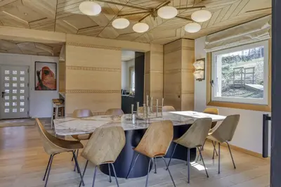 a dining room with a large marble table and chairs at Chalet Boucle in Megève