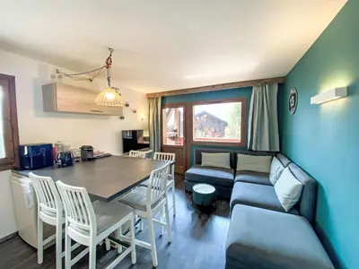 a kitchen and living room with a table and a couch at Apartment Les Grands Balcons by Interhome in Les Houches