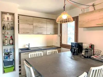a kitchen with a table and chairs and a counter top at Apartment Les Grands Balcons by Interhome in Les Houches
