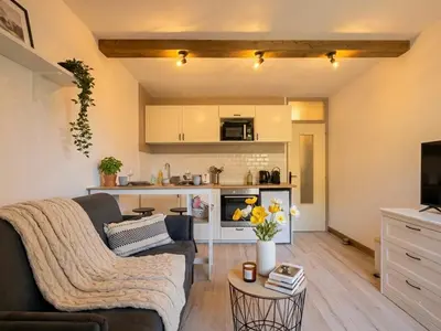 a living room with a couch and a kitchen at Charmant appartement à Saint-Gervais-les-Bains, idéal pour vos vacances à la montagne in Saint-Gervais-les-Bains