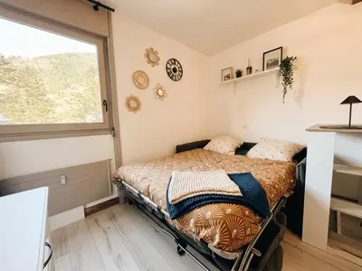 a living room with a couch and a kitchen at Charmant appartement à Saint-Gervais-les-Bains, idéal pour vos vacances à la montagne in Saint-Gervais-les-Bains